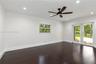 Dark wood-finish flooring, recessed lighting, ceiling fan, single-hung window, and glass-paned double doors