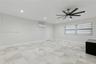 Interior space featuring large-format tile flooring, a multi-blade ceiling fan, recessed lighting, and a wall-mounted climate control unit