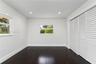 Dark wood-finish flooring, recessed lighting, and double bi-fold louvered closet doors