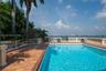 Swimming pool with tile surround, terracotta paver decking, decorative stone balustrade, and direct waterfront access