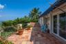 Terrace featuring terracotta tile flooring, wrought-iron railings, a retractable fabric awning, and dual-pane glass doors