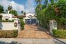 Mediterranean-style stucco exterior featuring a gated entrance, terracotta-tiled roof, paver driveway, and a two-car garage