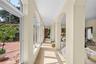 Hallway featuring an arched colonnade, tile flooring, and floor-to-ceiling windows