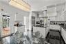Gourmet kitchen featuring high-gloss cabinetry, a central island with a stone countertop, stainless steel appliances, a cylindrical range hood, and a 