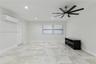 Interior space featuring large-format stone-finish floor tiling, recessed lighting, a multi-blade ceiling fan, a wall-mounted ductless climate control