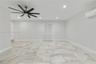 Large-format tile flooring, multi-blade ceiling fan, recessed lighting, and wall-mounted climate control unit