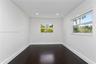 Interior space featuring dark wood-finish flooring, white walls, recessed ceiling lighting, and horizontal sliding windows