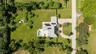 Aerial perspective featuring an expansive lot, a private swimming pool, solar panels, and a paved circular driveway