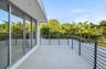Balcony featuring large-format tile flooring, metal horizontal railing, and expansive floor-to-ceiling glass sliding doors