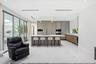 Chef’s kitchen featuring full-height matte cabinetry, a waterfall-edge stone island, built-in stainless steel appliances, polished stone flooring, and