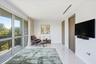 Floor-to-ceiling glass windows, stone flooring, wood-finish interior doors, and a recessed linear ceiling light fixture