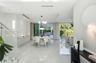 Large-format polished stone flooring, recessed ceiling lighting with tray detail, glass-panel staircase railing, built-in cabinetry, and expansive sli