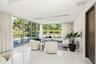 Floor-to-ceiling glass walls, polished stone flooring, recessed ceiling lighting, and wood-finish interior door