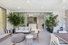 Covered patio featuring large-format stone-finish flooring, recessed ceiling lighting, and expansive floor-to-ceiling multi-panel sliding glass doors 
