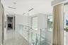 Hallway featuring polished stone flooring, glass panel railing, recessed ceiling lighting, and floor-to-ceiling windows