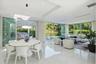 Open-concept living space featuring floor-to-ceiling glass sliding doors, polished tile flooring, recessed ceiling lighting, and a tray ceiling design