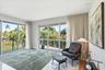 Floor-to-ceiling sliding glass doors, polished stone flooring, recessed lighting, and a metal-railed balcony