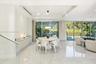 Open-concept interior featuring large-format tile flooring, floor-to-ceiling glass sliding doors, recessed lighting, and custom built-in cabinetry wit