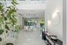 Double-height entryway featuring polished tile flooring, glass-panel staircase railing, recessed lighting, and wall-mounted circular accent fixtures