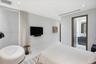 Neutral-toned interior featuring recessed lighting, smooth wall finishes, stone-style flooring, and floor-to-ceiling drapery