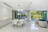 Large-format polished tile flooring, recessed ceiling lighting, built-in floor-to-ceiling cabinetry, and expansive multi-panel sliding glass doors