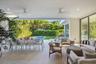 Covered patio featuring large-format stone-finish flooring, recessed lighting, ceiling fans, floor-to-ceiling glass sliding doors, and direct access t