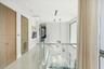 Hallway featuring large-format light tile flooring, wood-finish interior doors, recessed lighting, and a glass panel railing
