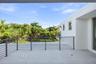 Elevated terrace featuring a smooth concrete floor, horizontal metal railing, and white stucco exterior walls