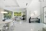 Open-concept interior featuring floor-to-ceiling glass walls, large-format tile flooring, recessed lighting, and sculptural wall-mounted fixtures