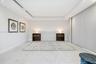 Tray ceiling with recessed lighting, large-format tile flooring, built-in wooden nightstands, and expansive wall-to-wall sliding door panels