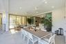 Covered patio featuring large-format stone-finish tile flooring, recessed ceiling lighting, ceiling-mounted fans, and sliding glass wall systems