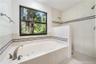 Jetted tub and walk in shower with shower heads on both walls.