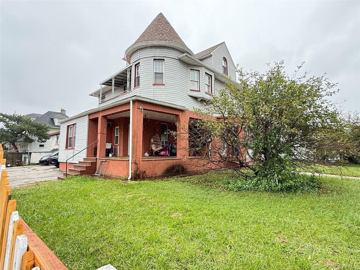 Victorian-style exterior featuring a corner turret, multi-level facade, covered wrap-around porch, and gable roofline