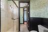 The shared part of this bathroom has a fully tiled shower with custom glass enclosure.