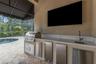 Where you will find a built-in summer kitchen with gas grill, refrigeration units, sink and more!