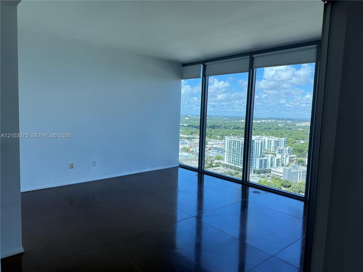 Floor-to-ceiling windows with dark framing, expansive glass panels, and large-format tile flooring