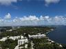 Aerial perspective showcasing coastal landscape, mature tree canopy, waterfront proximity, and high-rise surroundings