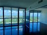 Floor-to-ceiling glass windows, polished concrete flooring, expansive balcony, and panoramic exterior scenery