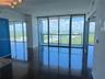 Floor-to-ceiling glass windows, polished tile flooring, metallic track lighting, and a glass-paneled balcony