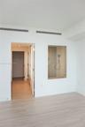 Wood-finish flooring, glass-enclosed shower stall with neutral tile surround, and recessed ceiling lighting