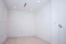 Minimalist interior featuring white wall finishes, wood-finish flooring, and recessed ceiling lighting