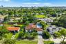 Single-story residence featuring a tile roof, built-in swimming pool, paved driveway, and mature landscaping