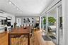 Living area featuring wood-finish flooring, built-in cabinetry, ceiling-mounted track lighting, and expansive sliding glass doors providing access to 