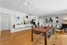 Living area featuring wood-finish flooring, ceiling-mounted track lighting, and built-in wall cabinetry with integrated desk surface