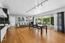 Living space featuring wood-finish flooring, ceiling-mounted track lighting, and expansive sliding glass doors