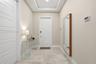 Entryway featuring large-format tile flooring, a tray ceiling, and a paneled entry door