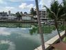 Waterfront bulkhead featuring concrete seawall and palm trees
