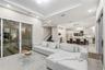Open-concept living space featuring a tray ceiling, recessed lighting, large sliding glass doors, neutral tile flooring, and a kitchen with an oversiz