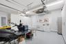 Garage space featuring extensive wall-to-wall built-in cabinetry, epoxy-finished flooring, and overhead lighting