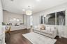 Spacious room featuring wood-finish flooring, extensive built-in cabinetry, a modern tiered drum pendant light, and a large horizontal window